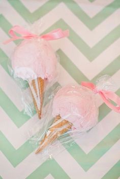 two ice cream cones wrapped in plastic and sitting on top of a chevron table