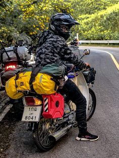 a man sitting on the back of a motorcycle next to a yellow and black bag