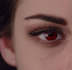 a woman with red eyeliner and long lashes