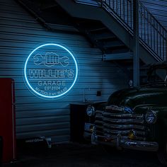 an old truck parked in front of a building with a neon sign that reads willie's garage