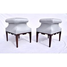 two white leather chairs sitting next to each other