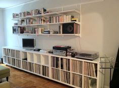 a white entertainment center filled with lots of records