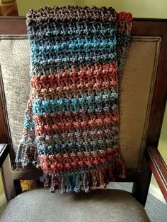 a crocheted blanket sitting on top of a chair