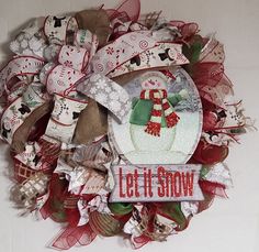 a wreath made out of fabric and ribbon with the words let it snow on it