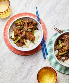 two bowls filled with food next to chopsticks on top of a tablecloth