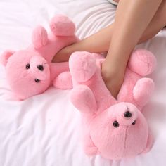 a woman laying on top of a bed with two pink teddy bears in her feet