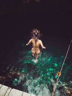 a woman is in the water with her arms outstretched