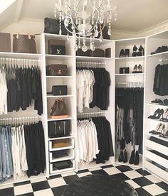 an organized closet with black and white checkered flooring, chandelier and handbags