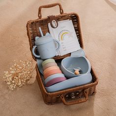 a wicker basket filled with dishes and cups on top of a carpeted floor