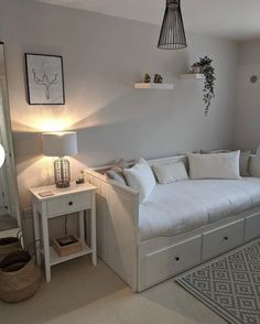 a living room with a couch, table and lamp on the wall next to it