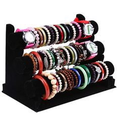 a rack with many bracelets and watches on it's display stand, all in different colors