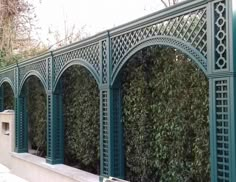 a green wall with arches and trelliss on it