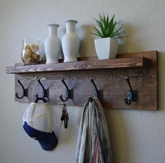 a wooden shelf with hooks and hats on it