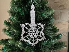 a white ornament hanging from the top of a christmas tree