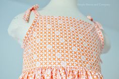 an orange and white dress on a mannequin