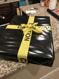 a black and yellow wrapped gift sitting on top of a counter