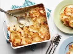 a casserole dish with potatoes is shown on a plate and next to a fork