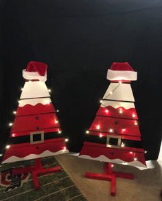 two red and white christmas trees with lights on them