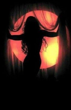 the silhouette of a woman standing in front of a curtain