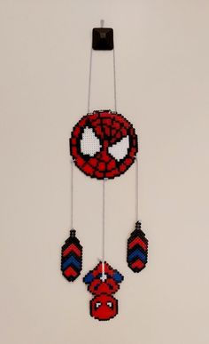 a beaded spiderman mobile hanging on a wall