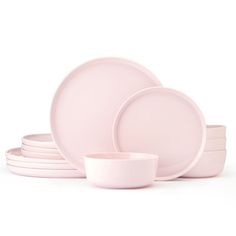 the pink dishes are stacked on top of each other, with one empty bowl in front