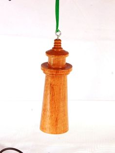 a wooden lighthouse ornament hanging from a green cord