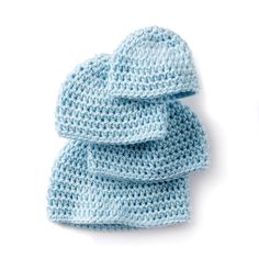 three crocheted hats on top of each other, one blue and the other white