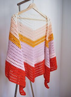 a crocheted sweater hanging on a clothes rack