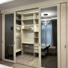 an empty bedroom with mirrored closet doors and shelves on the wall next to a bed