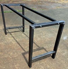 a black metal frame sitting on top of a cement ground