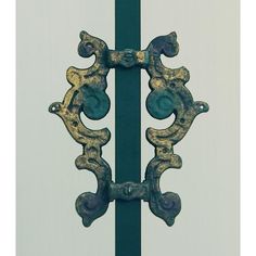 an old iron door handle on a green pole