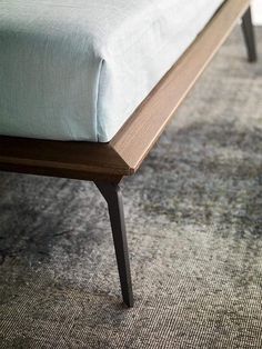 a close up of a bench on a carpeted floor with an area rug in the background