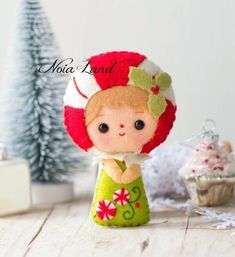 a small doll is standing next to a christmas tree