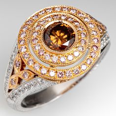 a fancy ring with an orange diamond surrounded by white and yellow diamonds in the center