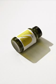 an open bottle of essential oils on a white surface with shadows from the top to the bottom