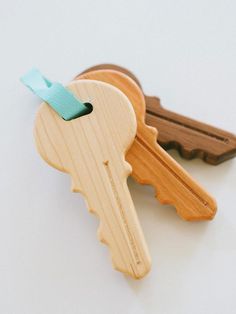 three wooden keys with blue ribbon attached to each keyhole and the words west elm written below them