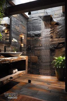 Modern rustic bathroom with sleek stone walls, a luxurious rain shower, rich wood accents, and decor elements like soft lighting and lush greenery, creating a stylish and relaxing atmosphere.