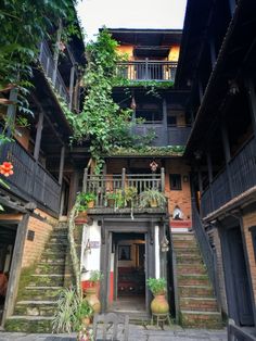 an apartment building with plants growing on the balconies