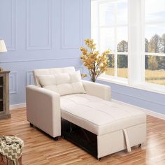 a living room with blue walls and white furniture in the corner, along with a large window