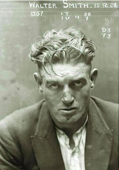 an old black and white photo of a man in a suit looking at the camera