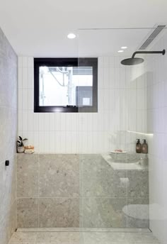 a bathroom with a shower, toilet and sink in it's corner window sill