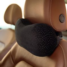 there is a black pillow on the back of a car seat