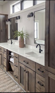 a large bathroom with double sinks and wooden cabinetry in the middle, along with a rug on the floor