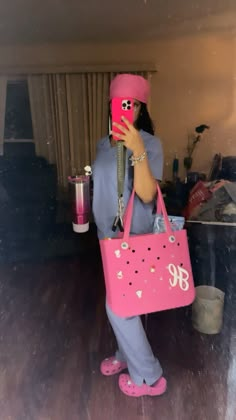 a woman in pink is holding a pink bag