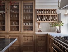 a kitchen filled with lots of wooden cabinets and counter top space next to a stove top oven