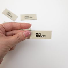 a hand holding a tag that says me made