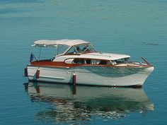 a small white boat floating on top of a body of water