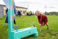 a woman is bending over to pick up something from the ground in front of her