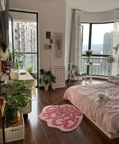 a bedroom with hardwood floors and large windows overlooking the cityscape is pictured in this image