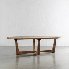 a wooden table sitting on top of a cement floor next to a white brick wall